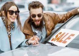 Excited couple buying a car during a sale without noticing red flags.