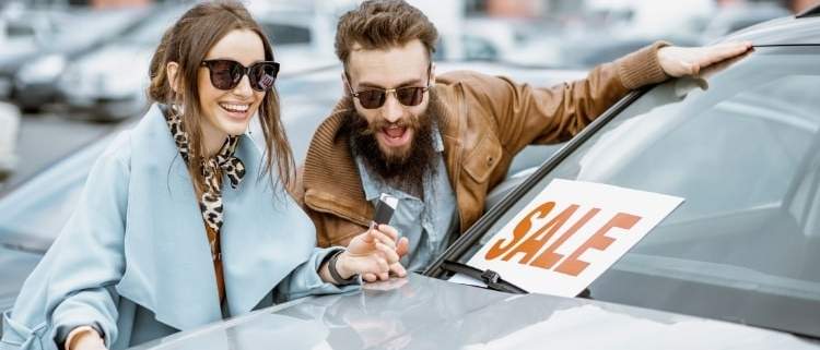 Excited couple buying a car during a sale without noticing red flags.