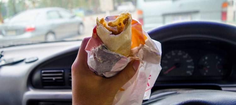 Car Innovations That Manufacturers Need to Consider. Eating a snack in a modern car.
