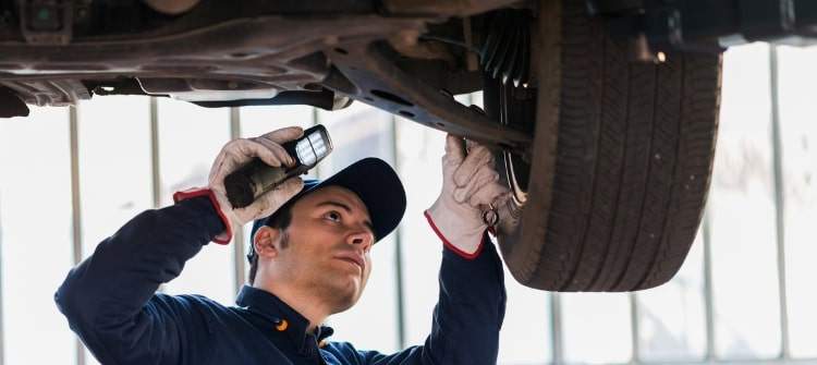 Are You Being Judged by Your Mechanic? A concerned mechanic inspecting a car, highlighting the real reasons your mechanic is judging you.