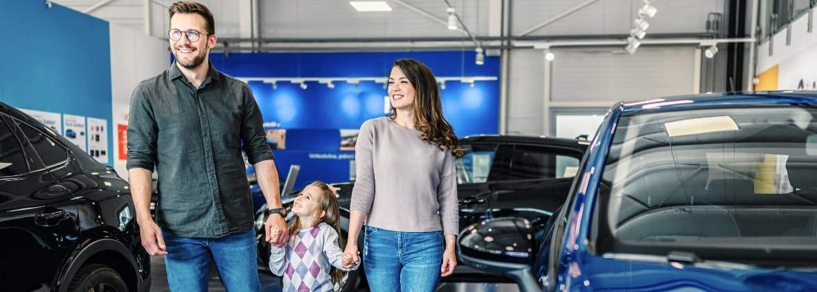 Happy family buying a new car at a dealership in 2024.