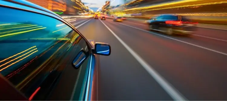 Common Mistakes Fast Drivers Make on Busy Roads. Fast drivers speeding on city road at night, illustrating risky driving behavior.