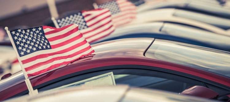 Memorial Day Weekend Car Shopping Sales Event. Row of cars with American flags on Memorial Day weekend car sale.