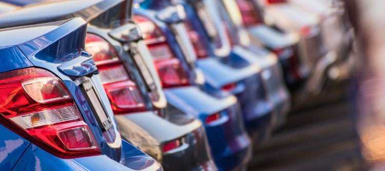 Multiple Price Quotes: The Smart Way to Get the Best Car Deal. Row of blue cars at a dealership, showcasing multiple options for car buyers comparing price quotes.