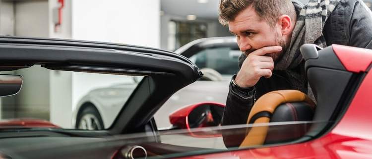 Young man trying to decide if he should purchase an off-lease vehicle.