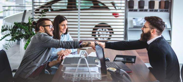 Tips on How to Finance a Car When You're Self-Employed. Self-employed individual reviewing car financing options at a dealership